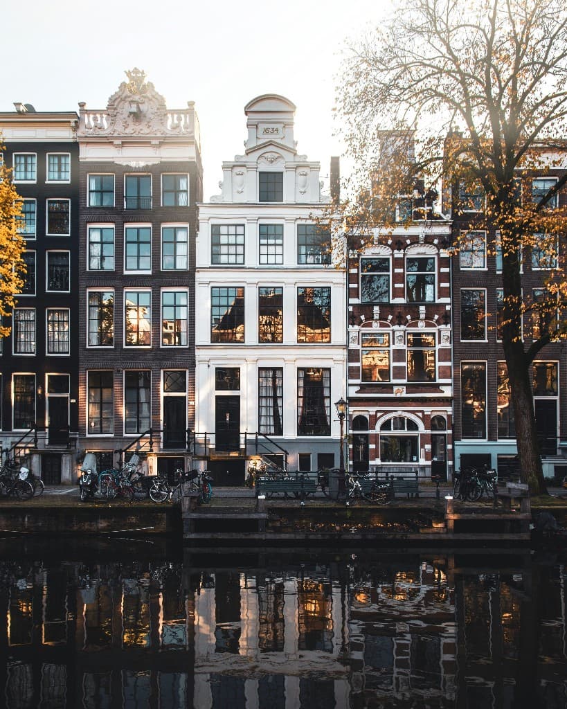 Maisons de canal à Amsterdam reflétées dans l'eau à l'heure dorée